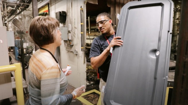 a man and woman looking at a large metal object
